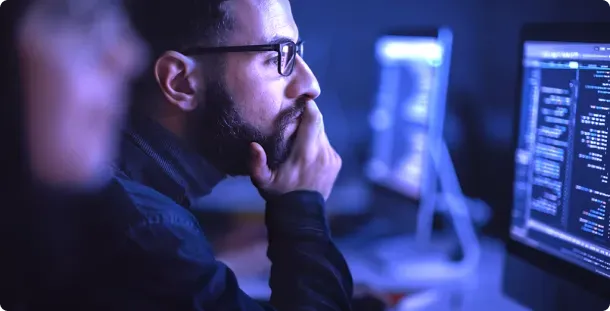 Trader working at a desk of screens